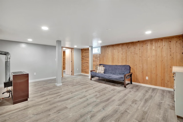 living area with light hardwood / wood-style floors and wood walls