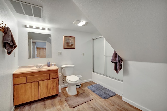 full bathroom with hardwood / wood-style flooring, vanity, toilet, and shower / bath combination with glass door