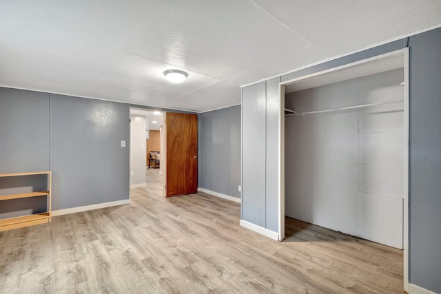 unfurnished bedroom with light hardwood / wood-style floors and a closet