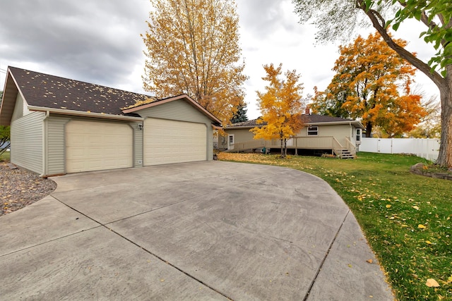 view of front of property with a garage, a wooden deck, and a front lawn