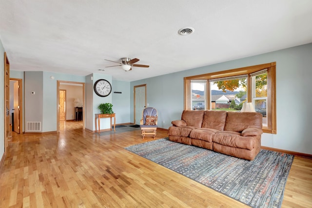 living room featuring ceiling fan and light hardwood / wood-style floors