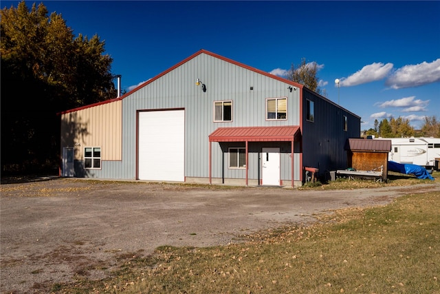154 Riverside Dr, Kalispell, MT 59901 - rear view of property featuring board and batten siding, a garage, metal roof, and an outdoor structure