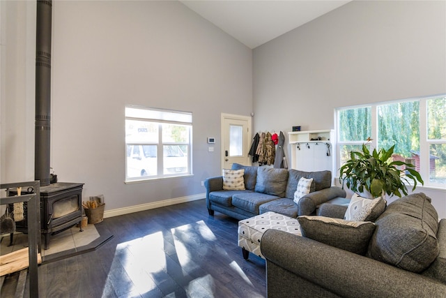 154 Riverside Dr, Kalispell, MT 59901 - living area featuring high vaulted ceiling, a wood stove, baseboards, and dark wood-style flooring