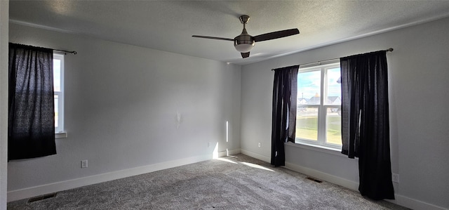 unfurnished room with ceiling fan, a textured ceiling, and light colored carpet