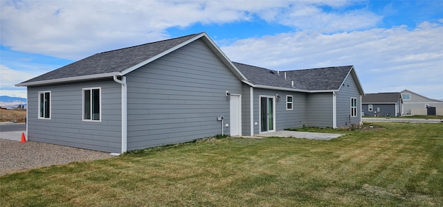 back of property featuring a patio area and a lawn