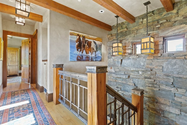 hall with light hardwood / wood-style flooring and beamed ceiling