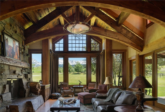 interior space featuring plenty of natural light, high vaulted ceiling, beamed ceiling, and light wood-type flooring