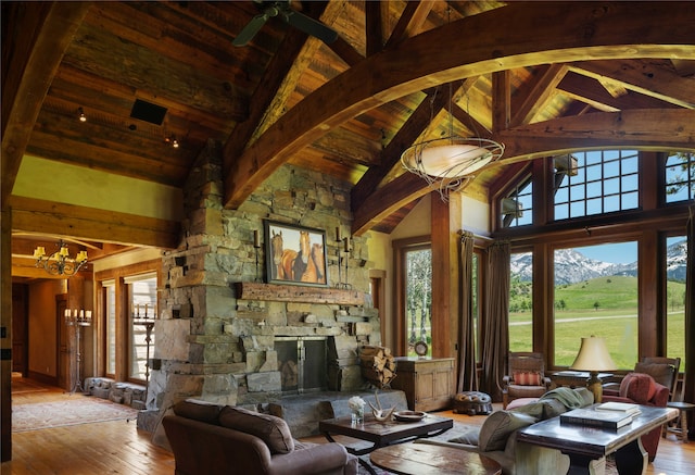 living room featuring beam ceiling, light hardwood / wood-style floors, wooden ceiling, a mountain view, and high vaulted ceiling