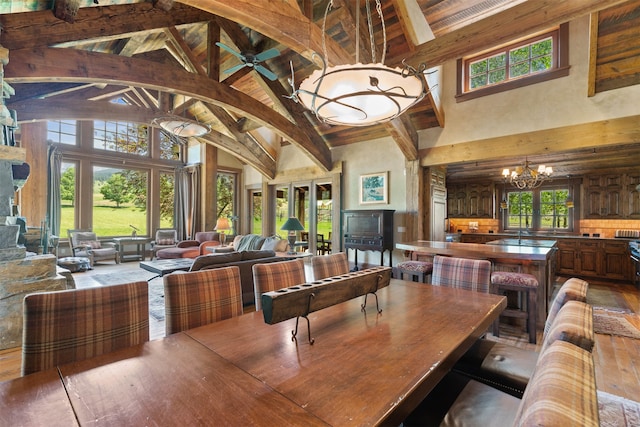 dining space featuring a healthy amount of sunlight, beamed ceiling, and high vaulted ceiling