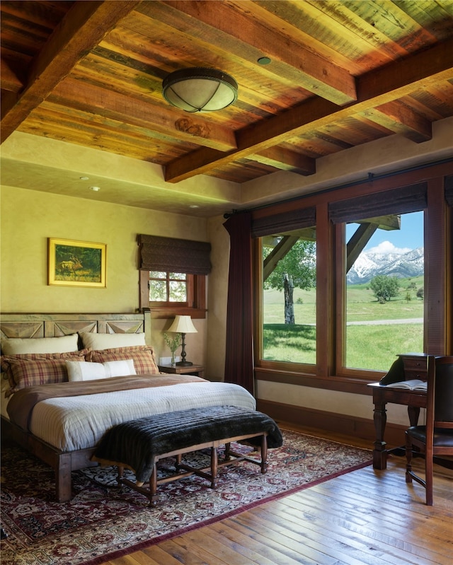 bedroom with beam ceiling, wood ceiling, wood-type flooring, and a mountain view