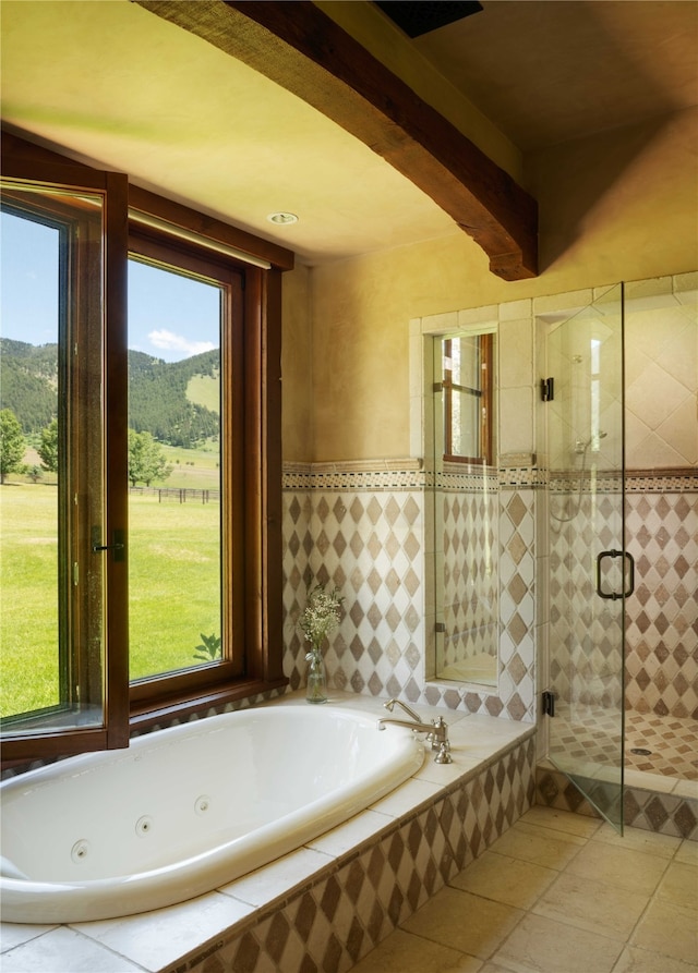 bathroom with a mountain view, tile patterned floors, a wealth of natural light, and shower with separate bathtub