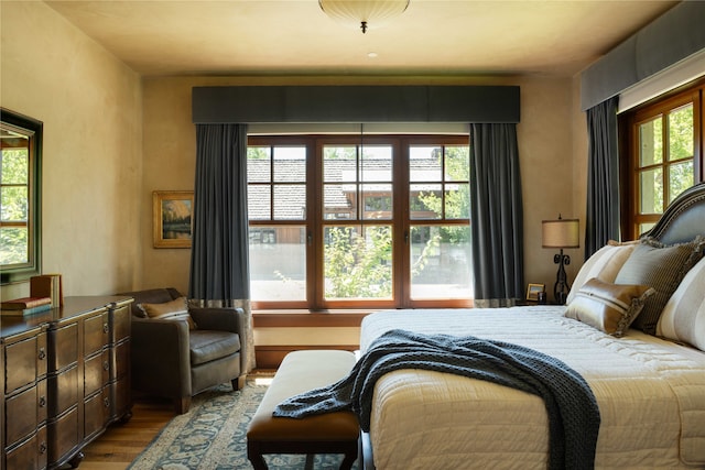 bedroom with multiple windows and light hardwood / wood-style floors