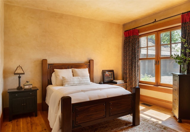 bedroom featuring light hardwood / wood-style floors and multiple windows