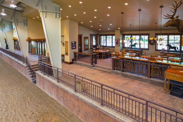 interior space with a towering ceiling, carpet, and a chandelier