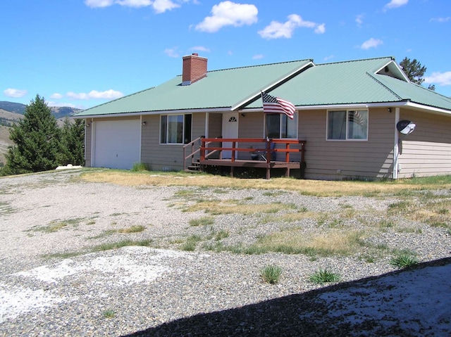 back of property with a wooden deck and a garage