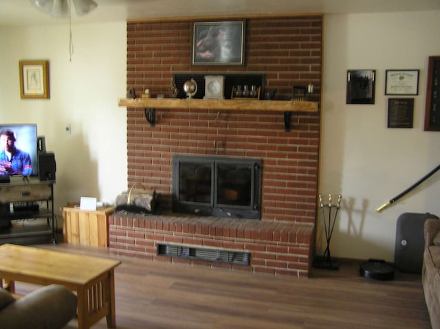 living room with wood-type flooring and a fireplace