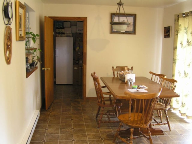 dining area featuring baseboard heating and dark tile patterned floors