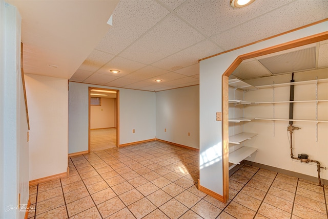 carpeted empty room featuring a drop ceiling