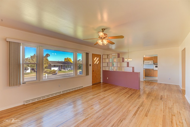 unfurnished dining area with sink, an inviting chandelier, and light hardwood / wood-style floors