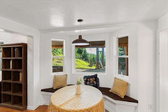 dining space with wood-type flooring and a textured ceiling