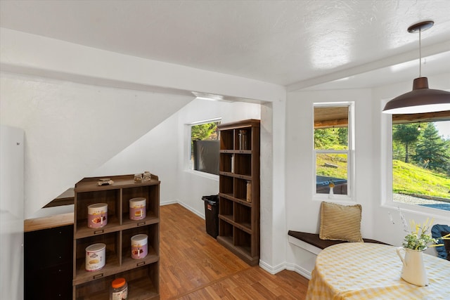 interior space with a textured ceiling, hardwood / wood-style flooring, and vaulted ceiling