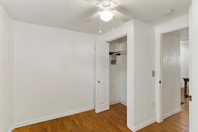 unfurnished bedroom featuring light hardwood / wood-style floors, a closet, and ceiling fan