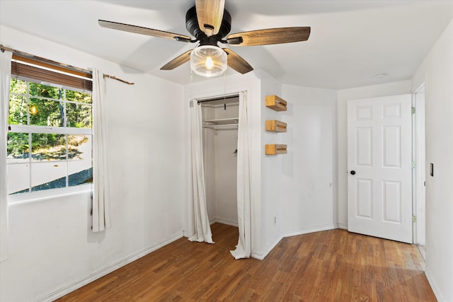 unfurnished bedroom featuring a closet, wood-type flooring, and ceiling fan