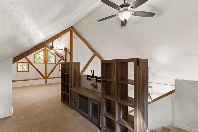 additional living space featuring lofted ceiling, carpet floors, a textured ceiling, and ceiling fan