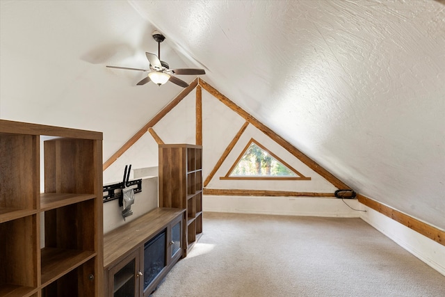 additional living space with a textured ceiling, carpet floors, ceiling fan, and vaulted ceiling