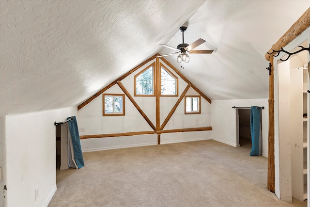 bonus room featuring vaulted ceiling, a textured ceiling, and light colored carpet