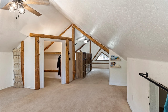 additional living space featuring lofted ceiling, a textured ceiling, light colored carpet, and ceiling fan