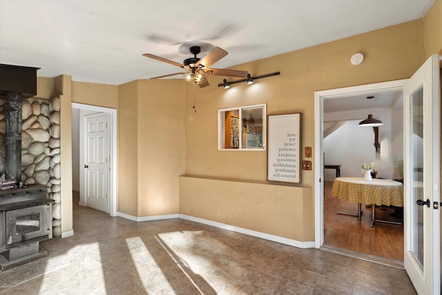 living room with a wood stove and ceiling fan