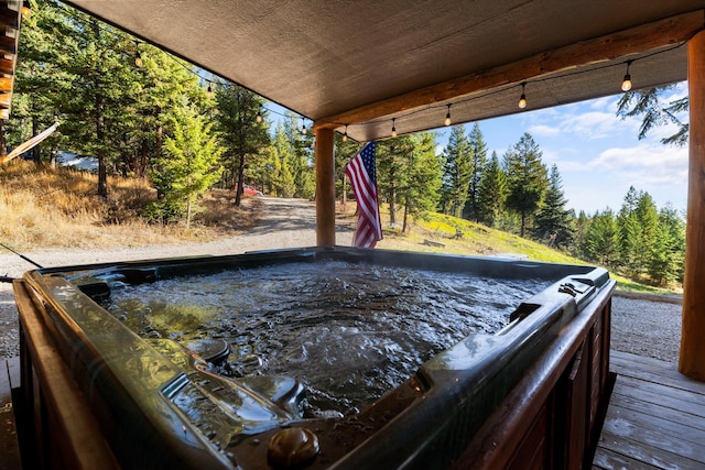 view of swimming pool with a hot tub and a deck