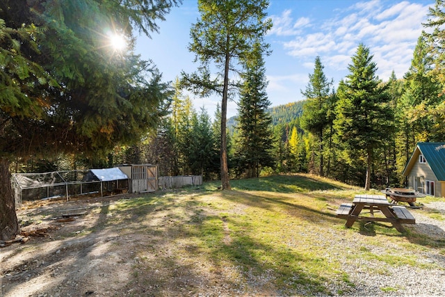 1424 Bierney Creek Rd, Lakeside, MT 59922 - view of green lawn with an outdoor structure, a wooded view, and exterior structure