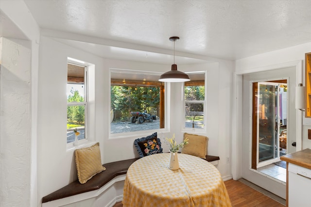 dining area with a textured ceiling, breakfast area, and wood-type flooring