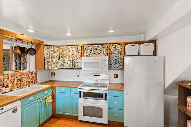 kitchen with backsplash, sink, light hardwood / wood-style floors, and white appliances