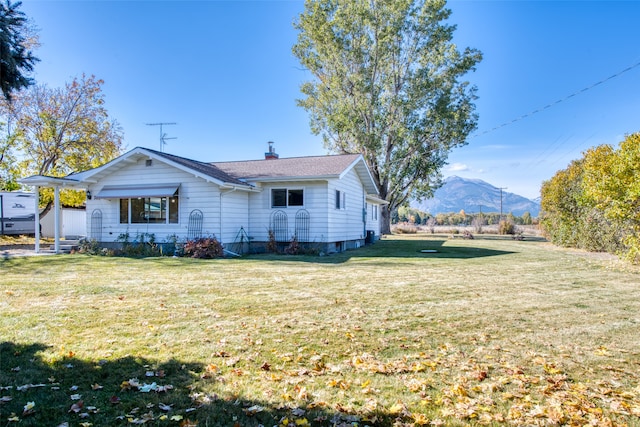 view of home's exterior with a yard and a mountain view