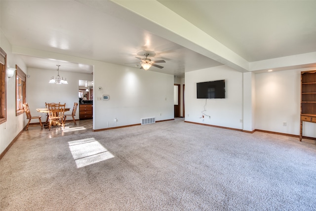 unfurnished living room featuring carpet floors and ceiling fan with notable chandelier