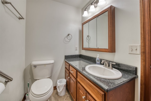 bathroom with tile patterned flooring, vanity, and toilet