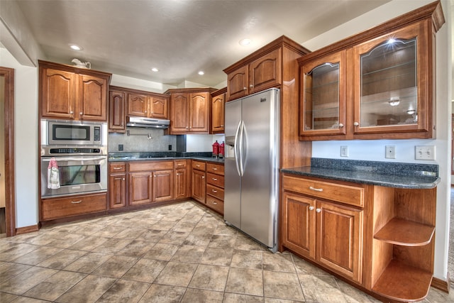 kitchen featuring dark stone counters, vaulted ceiling, and stainless steel appliances