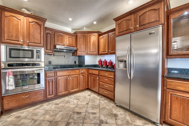 kitchen with built in appliances and dark stone countertops