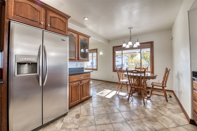 kitchen with dark stone counters, a chandelier, decorative light fixtures, and built in fridge