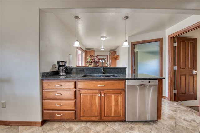 kitchen with dark stone counters, stainless steel dishwasher, hanging light fixtures, and sink