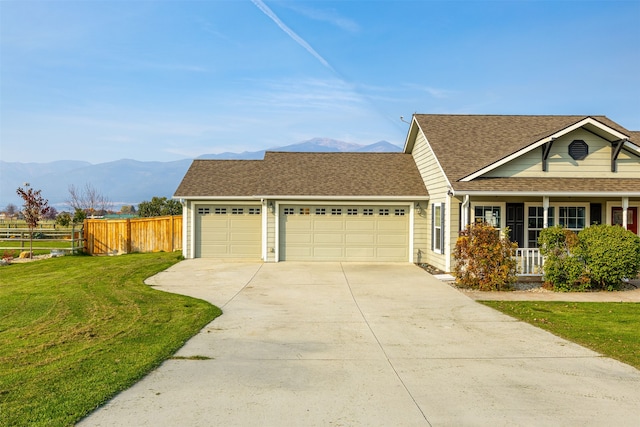 view of front of home featuring a front yard, a garage, and a mountain view