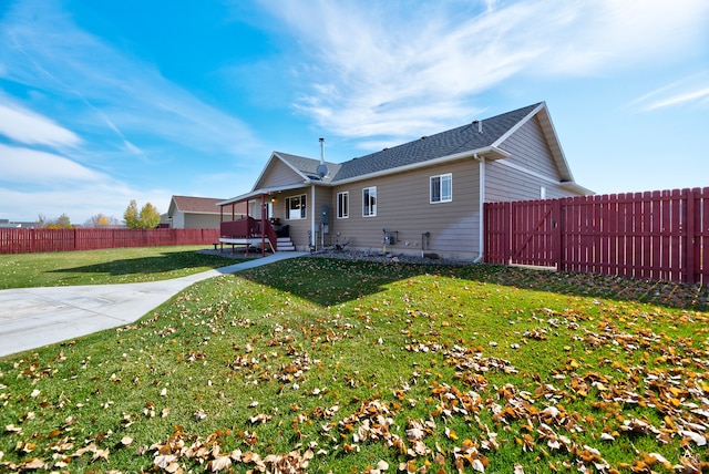 back of house with a patio and a lawn