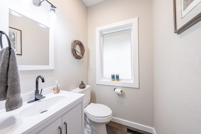 bathroom with vanity, wood-type flooring, and toilet