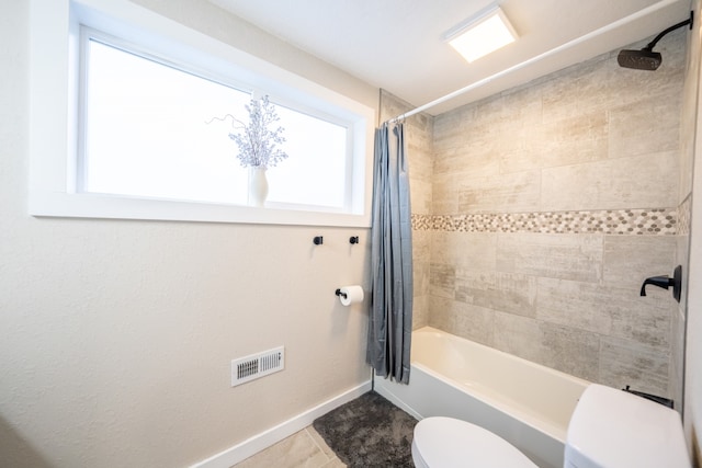 bathroom with toilet, tile patterned floors, and shower / tub combo with curtain