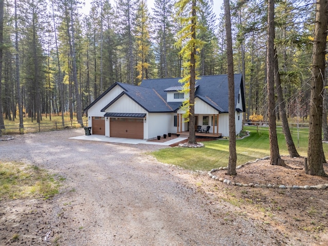 view of front of home featuring covered porch, a front yard, and a garage