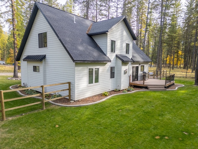 rear view of house with a deck and a lawn