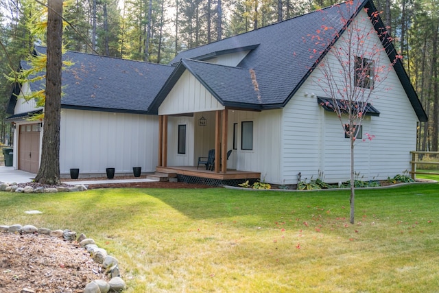 modern farmhouse style home with a front yard, covered porch, and a garage